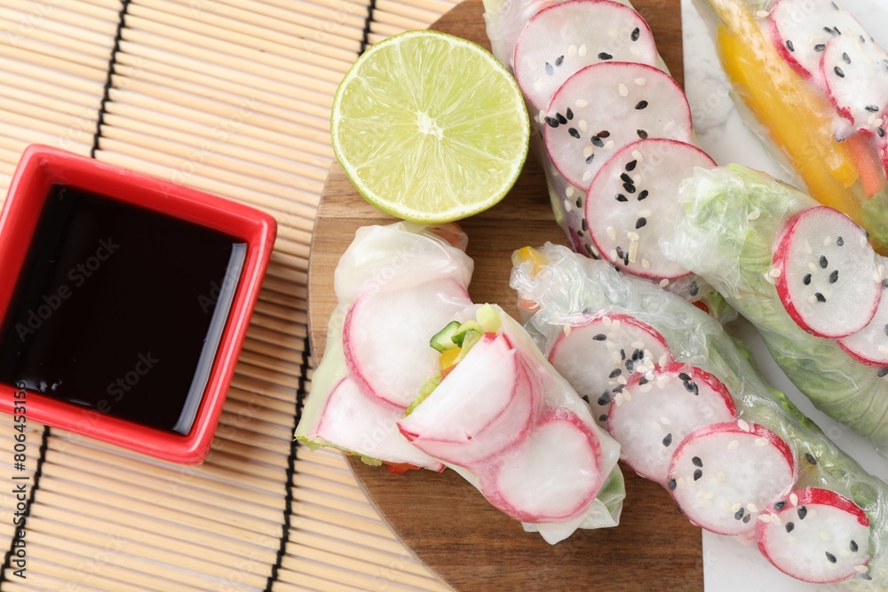 Delicious spring rolls, lime and soy sauce on table, top view Delicious spring rolls, lime and soy sauce on table, top view