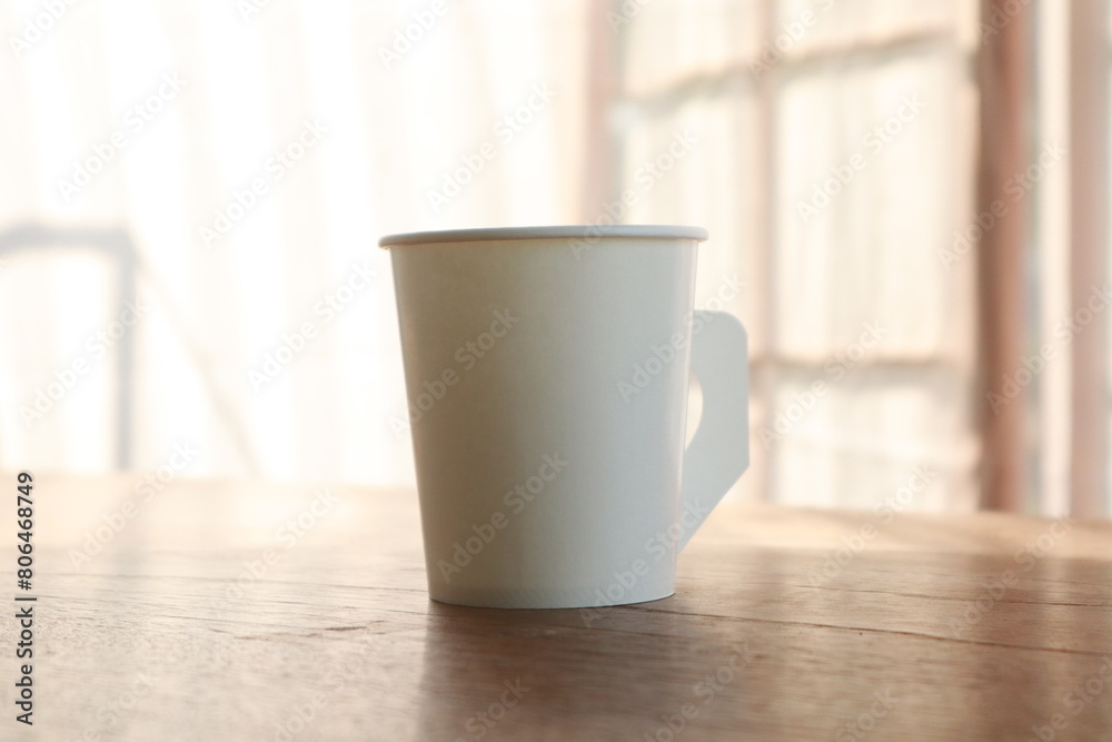 On this desk, amidst an office background, sits a coffee cup, offering a blank space for ideas. It's a modern workplace. On this desk, amidst an office background, sits a coffee cup, offering a blank space for ideas. It's a modern workplace.