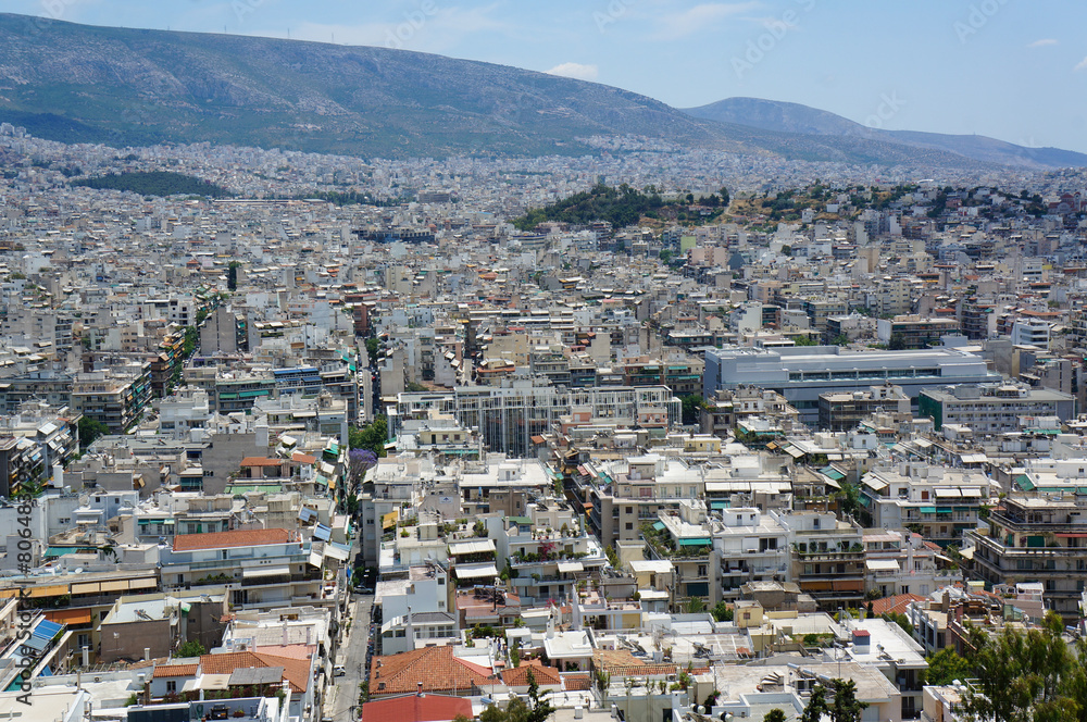 青空のもと直線道路が複数走るアテネの町並み