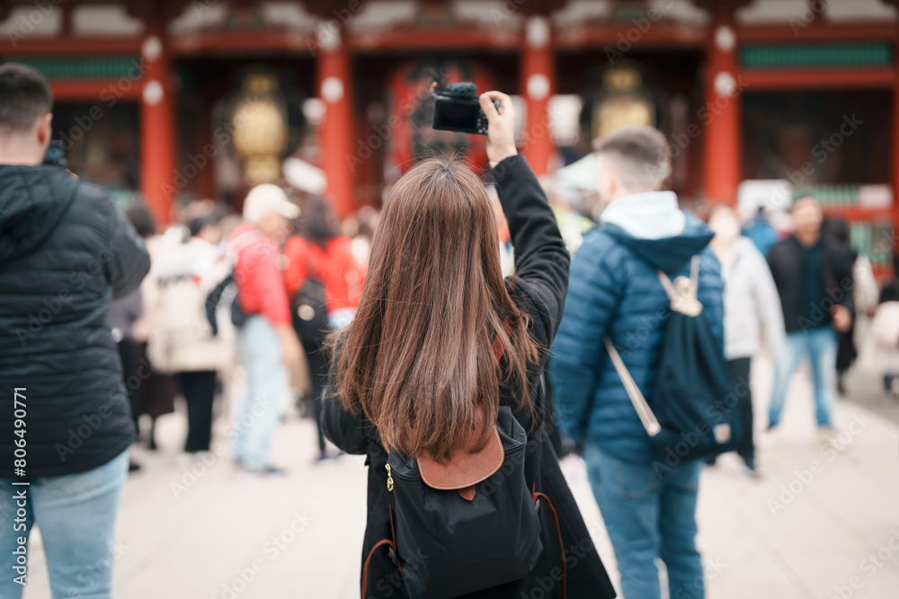 Fototapeta premium Tourist woman visit Sensoji Temple or Asakusa Kannon Temple is a Buddhist temple located in Asakusa, Tokyo Japan. Japanese sentence on red lantern means Thunder gate.