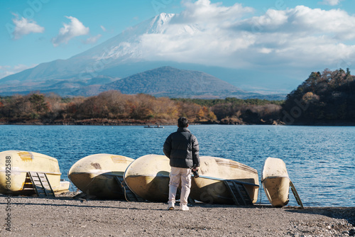 man  tourist enjoy with Fuji Mountain at Lake Shoji, happy Traveler sightseeing Mount Fuji and road trip Fuji Five Lakes. Landmark for tourists attraction. Japan Travel, Destination and Vacation photo