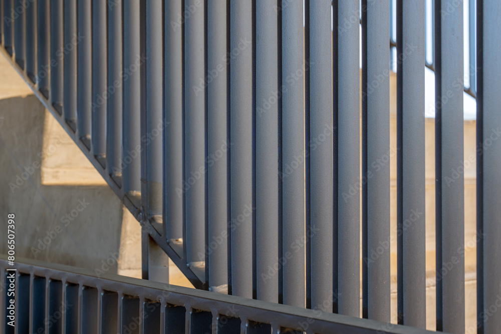 Close-up photo of a modern gray metal railing and concrete stair case between floors.
Close-up photo of a modern gray metal railing and concrete stair case between floors.