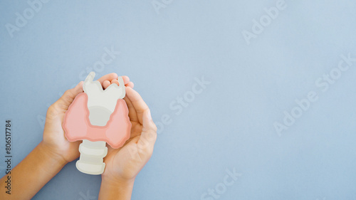 Hands holding Thyroid gland paper cutout, world thyroid day, thyroid cancer concept
