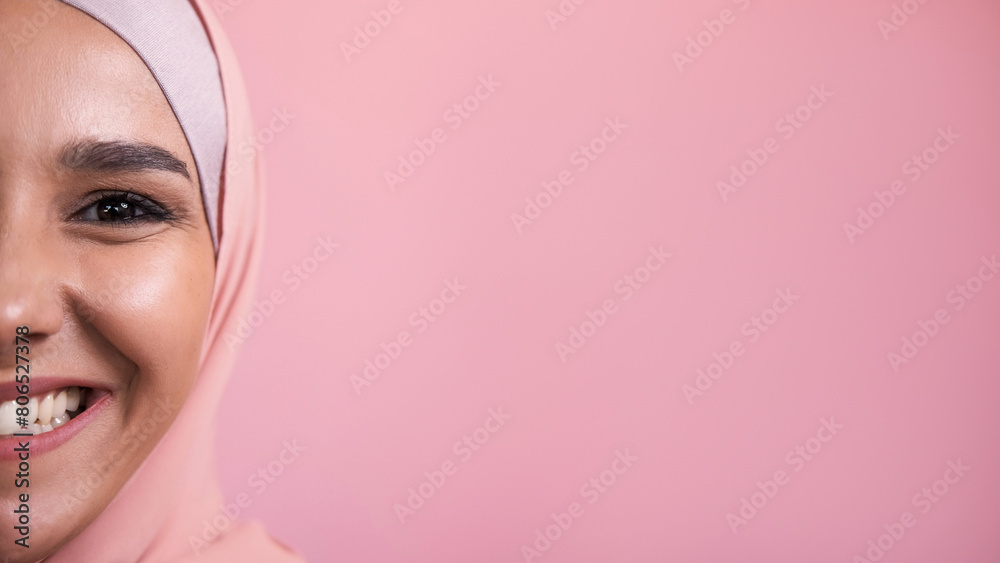 Joyful smile. Happy emotion. Half face portrait of amused satisfied pleased cheerful woman in hijab isolated on pink empty space background. Joyful smile. Happy emotion. Half face portrait of amused satisfied pleased cheerful woman in hijab isolated on pink empty space background.