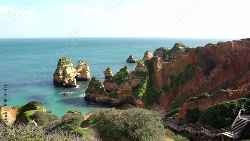 Praia do Camilo, Algarve, Lagos, Portugal; Long Wooden Stairs Leading Down To A Turquoise Water Beach With Spectacular Rock Formations. photo
