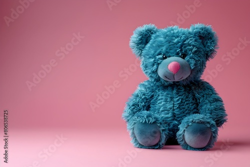 Un tierno oso de peluche color azul en un fondo rosa. Imagen ideal para tarjeta de felicitacion, cumpleaños, buenos deseos photo