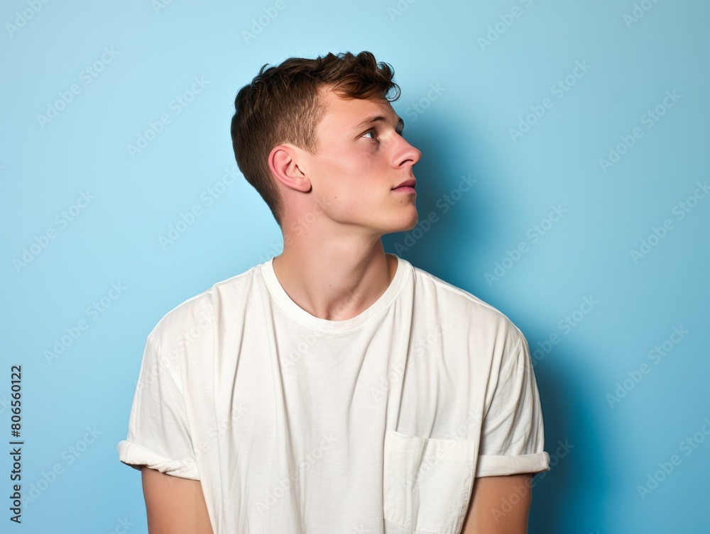 A young man in a white shirt is looking up at the sky A young man in a white shirt is looking up at the sky