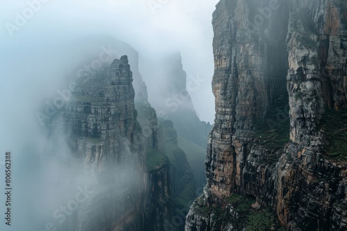 Explore the rugged terrain of a mountain range shrouded in mist and mystery, with jagged peaks disappearing into the clouds and hidden, Generative AI