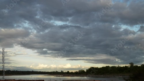 Serene River Landscape Under a Dramatic Cloudy Sky at Dusk