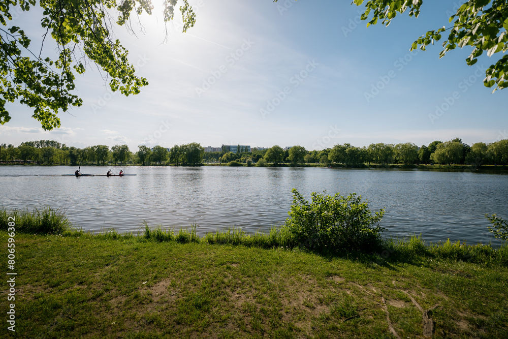 Valley of the Three Ponds in Katowice. Green areas in the city. Recreation zone. Kayakers floating on the city pond..Residential buildings in the background
