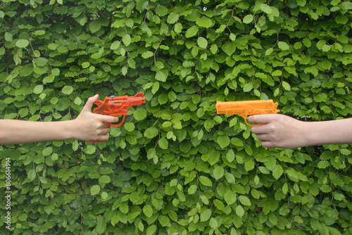 Water pistols in the hands of children. Children have fun with water guns in summer