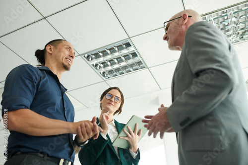 Smiling entrepreneurs answering tricky questions of their senior colleagues