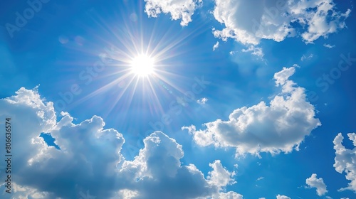 Bright sunshine with sun flares and clouds on clear blue sky background  hot summer concept