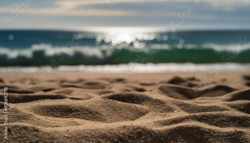 Close-up of sandy beach textures with out-of-focus waves in the background  concept of tranquility