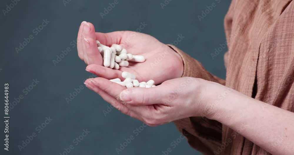 many pills in female hands on a dark background
many pills in female hands on a dark background