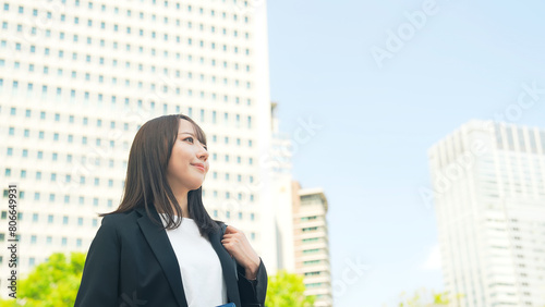 都市を見上げる女性ビジネスパーソン © metamorworks
