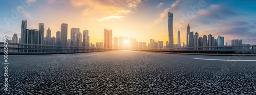 Empty asphalt road with city skyline background at sunset. Panorama view of empty black top surface for car advertising and product display presentation, banner