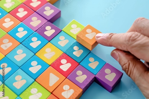man s hand holding a square tangram puzzle  over wooden table.