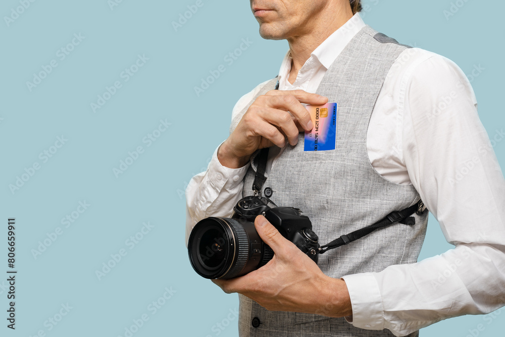 Successful male photographer with camera and credit card earn a lot of money, harmonious blend of technical expertise, artistic vision, and the pursuit of economic stability.