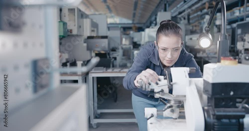 Wallpaper Mural Focused craftswoman grinding metal on precision machine Torontodigital.ca