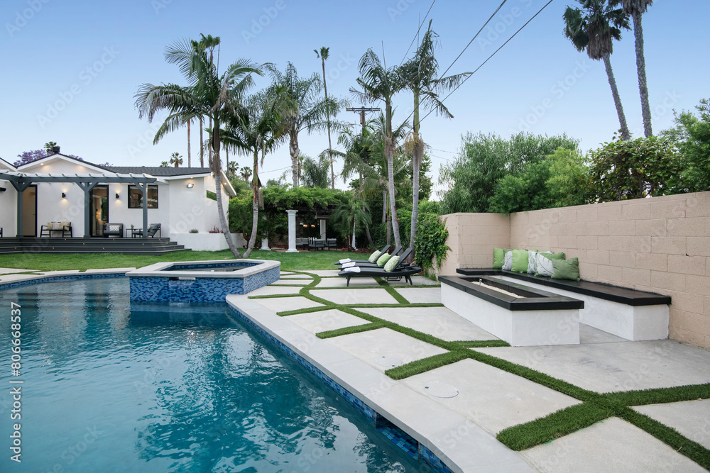 Backyard with a pool, and grassy lawn in a modern new construction home in Los Angeles