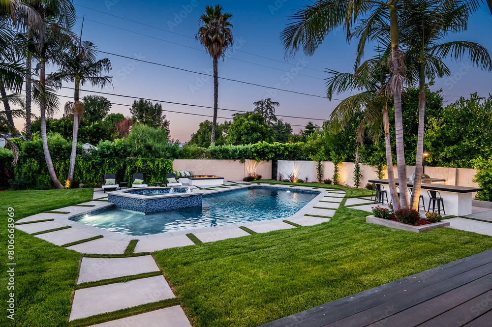 Backyard pool in a verdant garden setting in a modern new construction home in Los Angeles