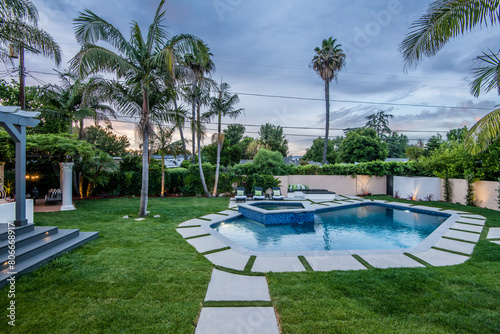 Backyard pool in a verdant garden setting in a modern new construction home in Los Angeles