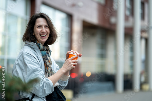 Cheerful woman holding coffee cup in the srteet photo