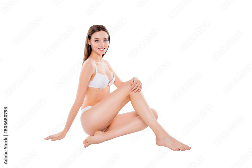 Portrait of skinny slim woman sitting over white background in bra and bikini looking at camera demonstrating perfect body thin legs Portrait of skinny slim woman sitting over white background in bra and bikini looking at camera demonstrating perfect body thin legs