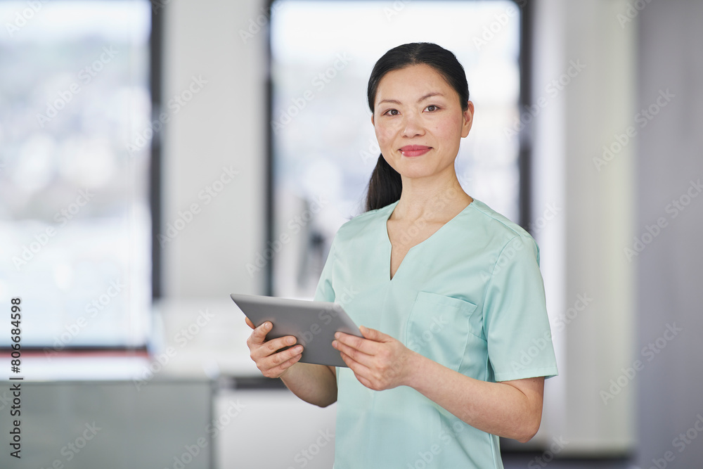 Portrait of nurse in scrubs holding digital tablet Portrait of nurse in scrubs holding digital tablet