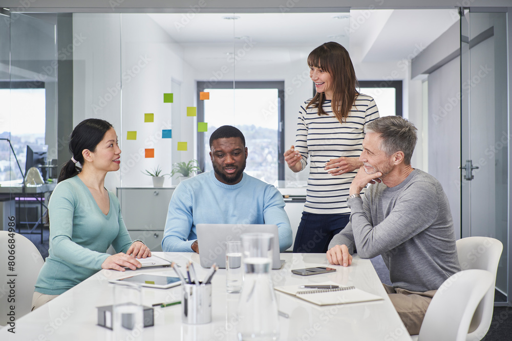© Westend61 - Businesswoman discussing with colleagues in office meeting room