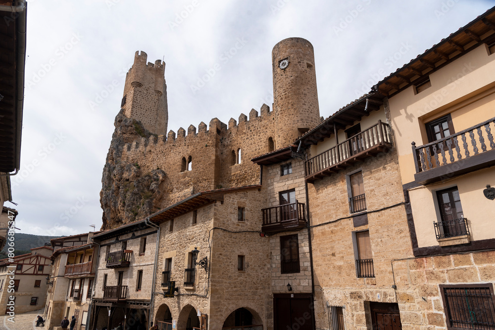 Streets of the touristy medieval town of Frías with small houses of wood-brick and stone and in the background its impressive castle in the province of Burgos.