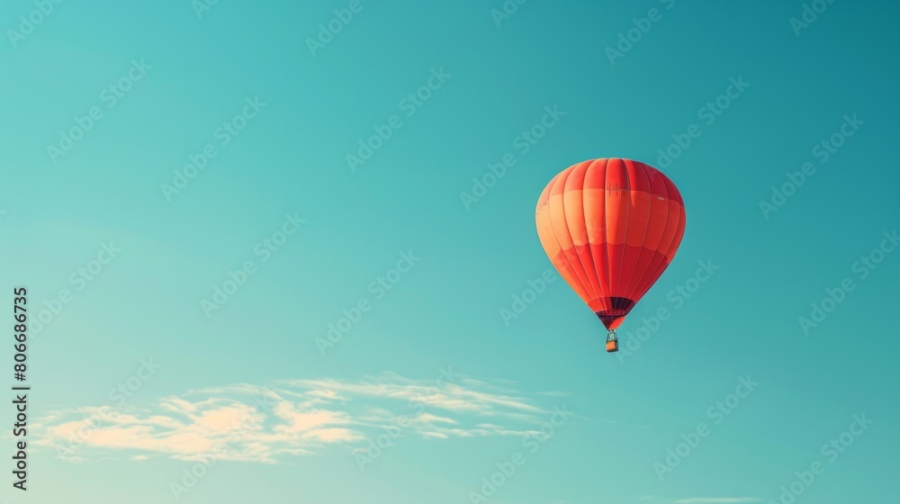 Naklejka premium A clear blue sky with a single hot air balloon floating peacefully.