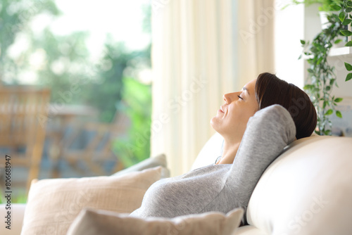 Woman relaxing sitting on a couch alone at home photo