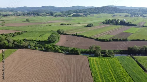 Pole uprawne i łąki z drzewami i górami w tle