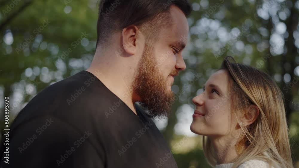 A young romantic couple gazes into each other eyes, expressing love and affection surrounded by a natural park setting. Romantic Couple Sharing a Tender Moment in Nature A young romantic couple gazes into each other eyes, expressing love and affection surrounded by a natural park setting. Romantic Couple Sharing a Tender Moment in Nature