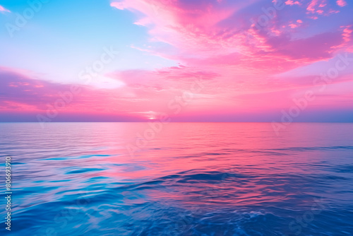 Surreal seascape with a vibrant pink sky reflecting over calm blue waters  creating a peaceful and picturesque scene.