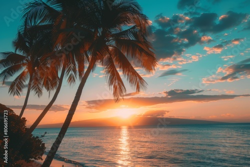 Golden sunset over tropical beach with palm trees