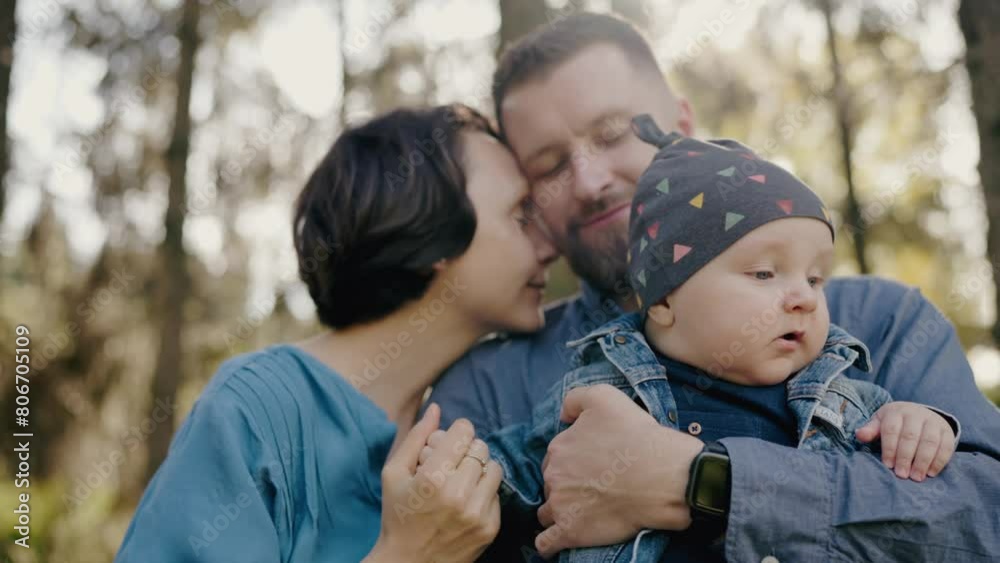 A heartwarming scene in the forest featuring loving parents kissing while embracing their baby boy. A tender family moment, surrounded by nature. Family Embracing in Nature A heartwarming scene in the forest featuring loving parents kissing while embracing their baby boy. A tender family moment, surrounded by nature. Family Embracing in Nature