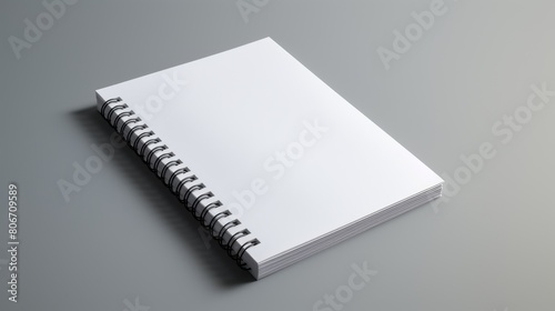 A white spiral notebook rests on a gray surface