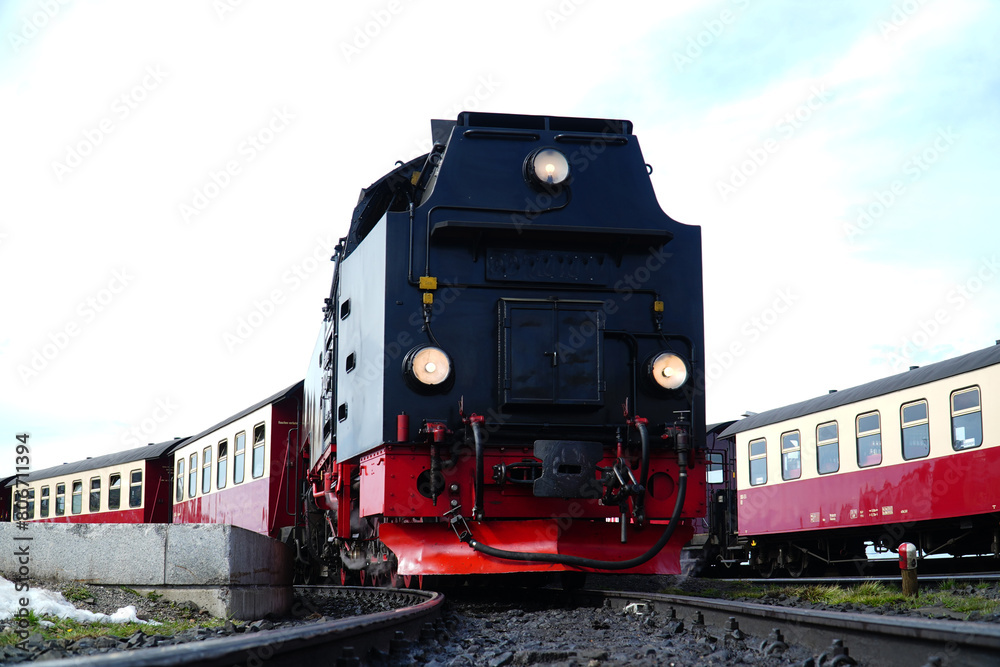 Obraz premium Locomotive of the traditional steam train on the Brocken narrow-gauge railroad in spring in the Harz National Park.