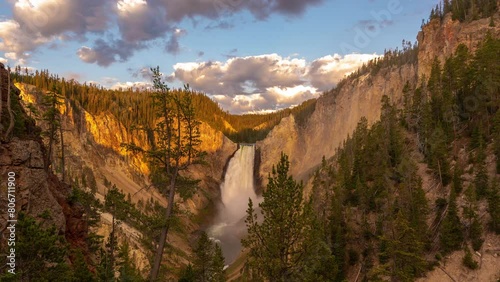 Timelapse, Lower Falls in Yellowstone National Park, Wyoming USA, Clouds Moving Above Sunny Landscape photo