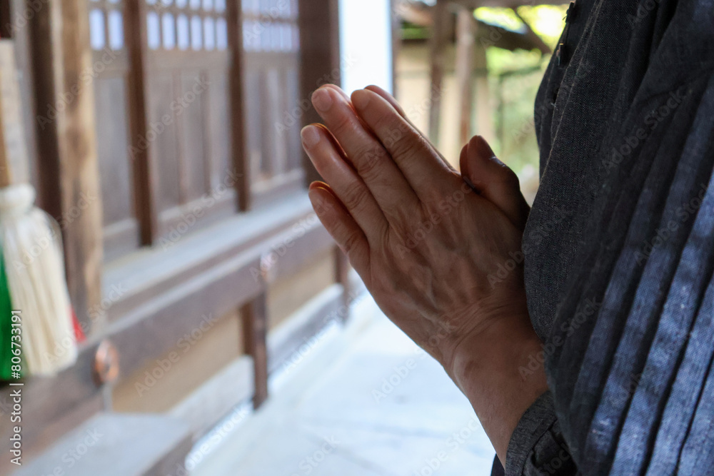 お寺で手を合わせる高齢女性の手元