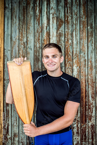 Portrat of young canoeist holding paddle. Concept of canoeing as dynamic and adventurous sport. photo