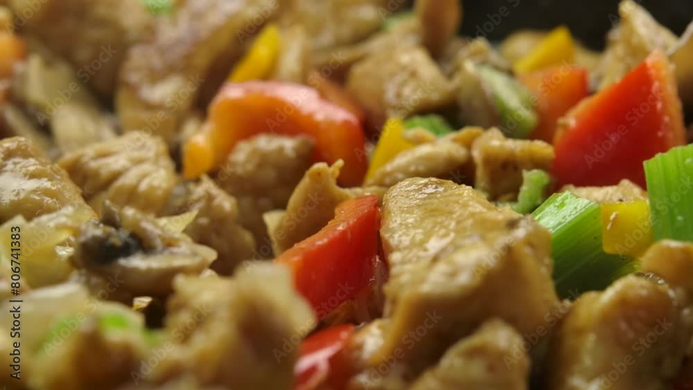 Spatula stirs pieces of chicken meat, vegetables and chopped mushrooms in a hot skillet. High quality 4k footage Spatula stirs pieces of chicken meat, vegetables and chopped mushrooms in a hot skillet. High quality 4k footage