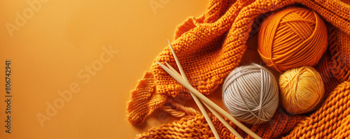 Warm Knitting Wool and Craft Tools on Vibrant Orange Background photo