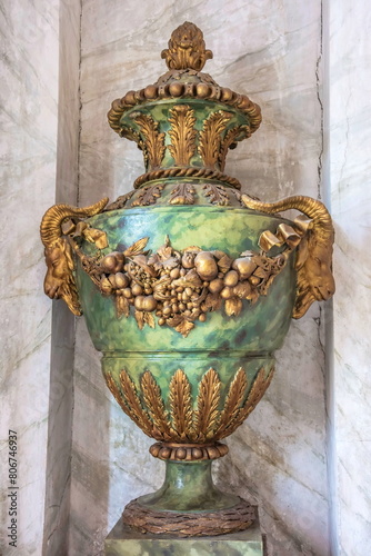 An ancient stone vase decorated with stucco in the form of a garland of fruits