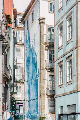 View of a street with different and typical facades with colored tiles in the Portuguese city of Porto, Portugal. © ikuday