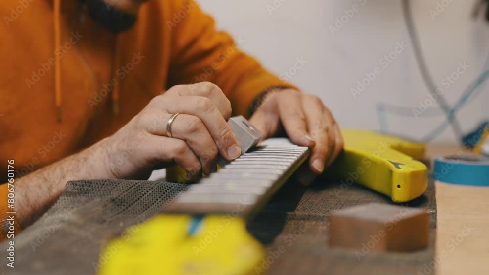 young man working on a guitar at the workshop. High quality 4k footage