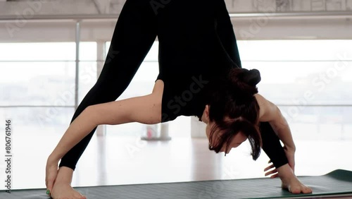 Yoga exercise in fitness pose, healthy woman in gym, female performing Prasarita Padottanasana pose. Female meditating for zen, healthcare and wellbeing. Motivation. Active lifestyle photo
